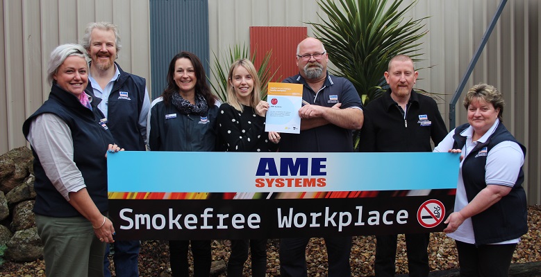 Workers from AME Systems holding a smokefree workplace sign